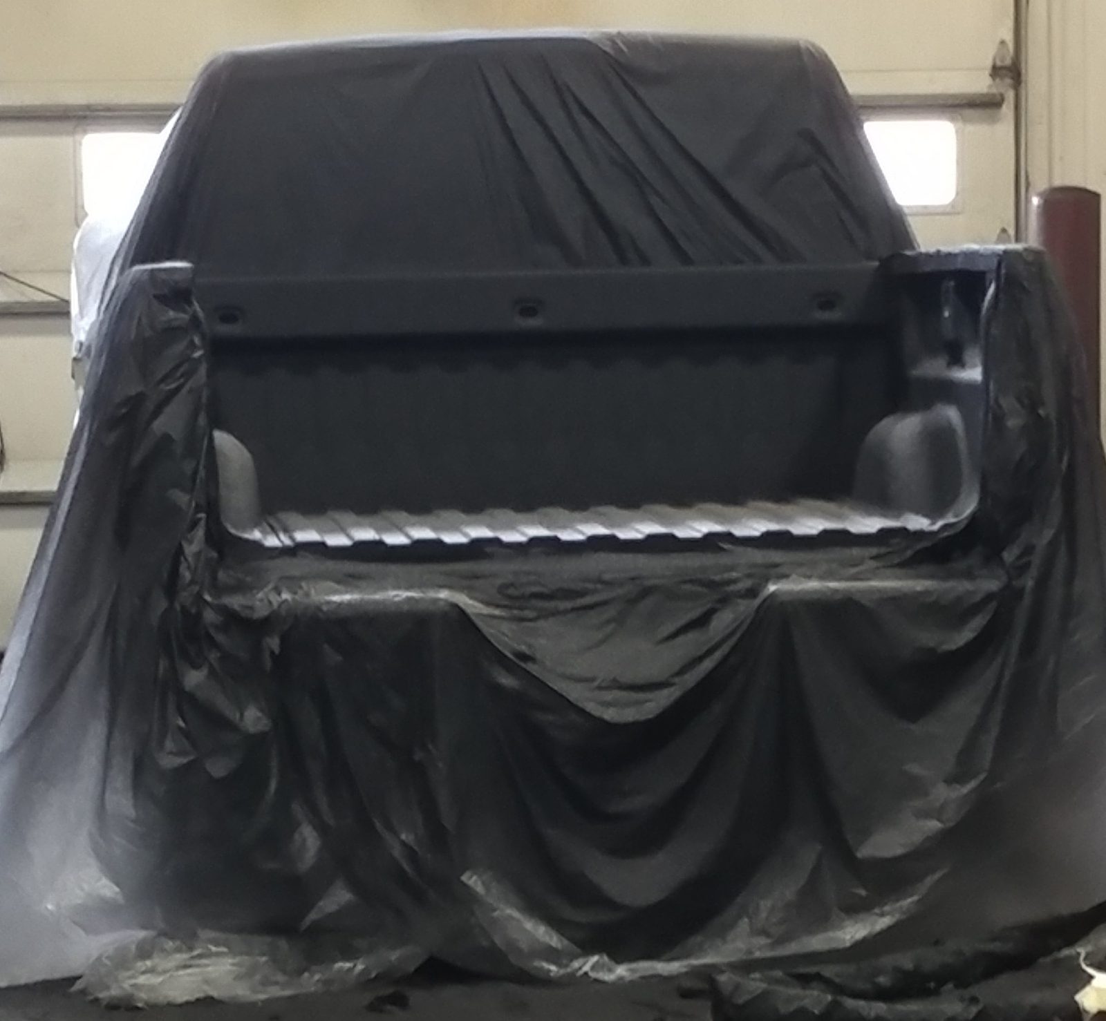 Applicator spraying SprayShield Pro on a vehicle underbody
