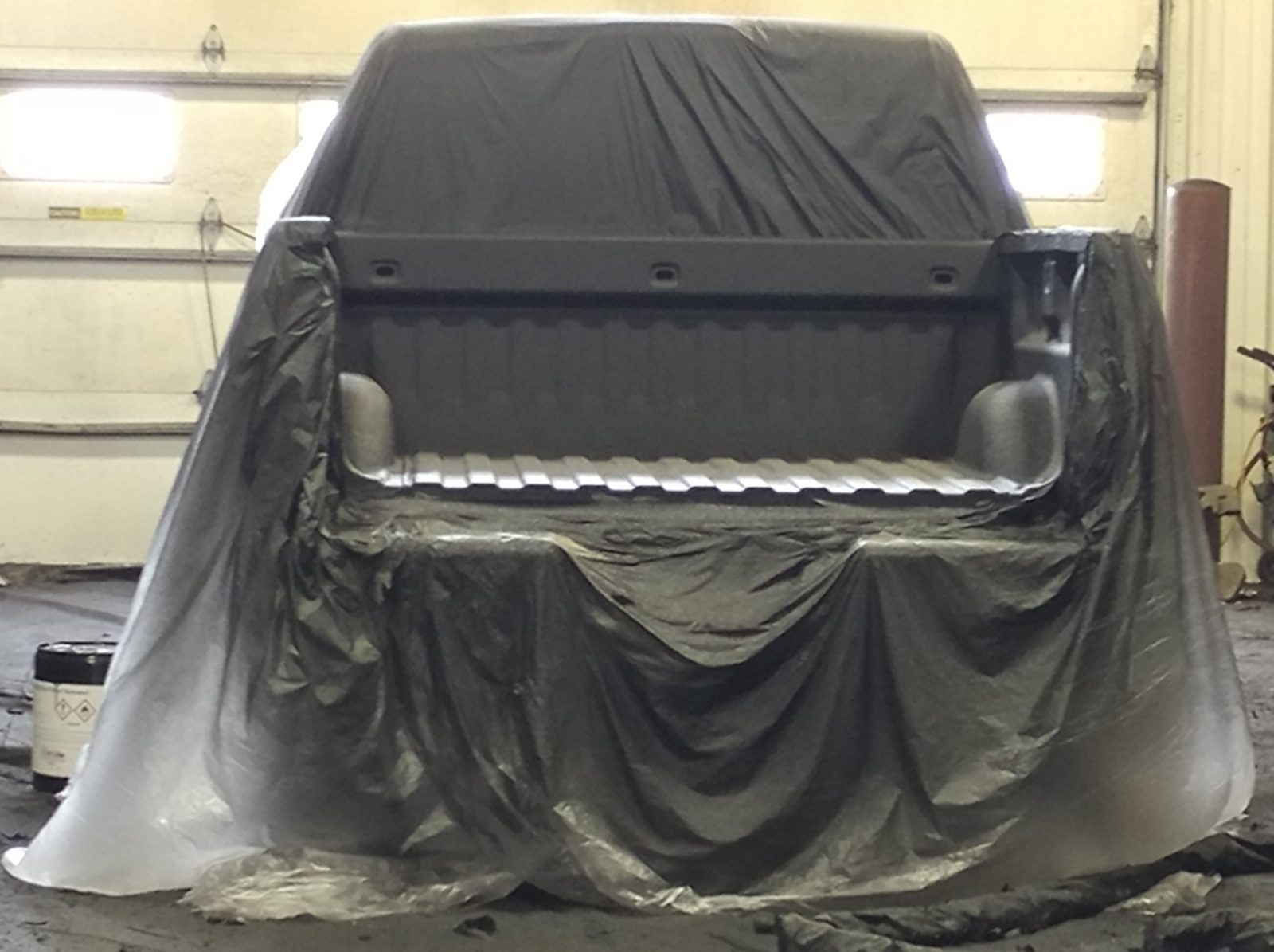 Professional applicator spraying rust proof coating with an undercoating gun